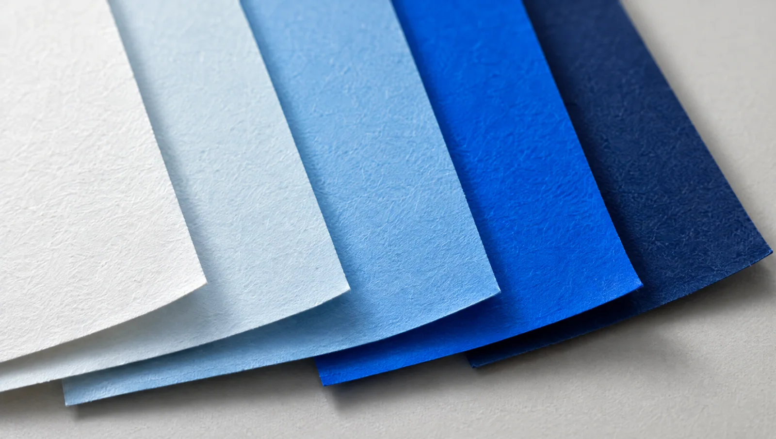 Aufgefächerte Papierbögen in Weiß, Hellblau, Himmelblau, Signalblau und Marineblau